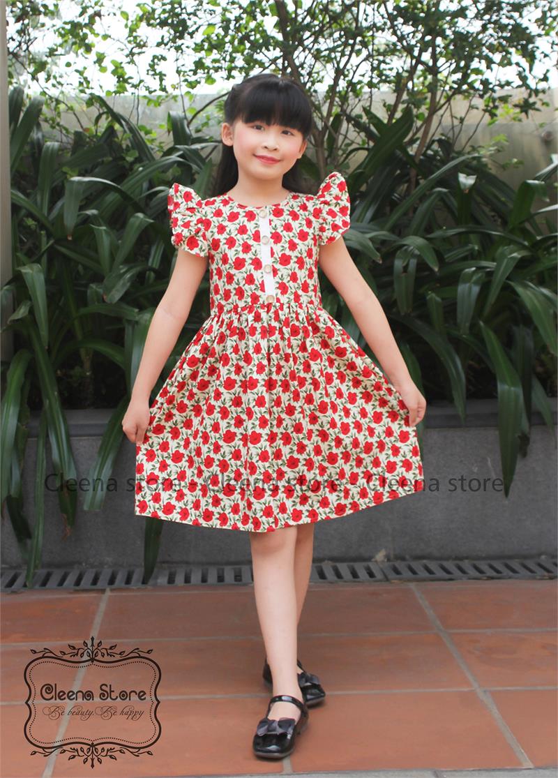 Đầm xòe tay cánh tiên nẹp trắng đính cúc hoa đỏ